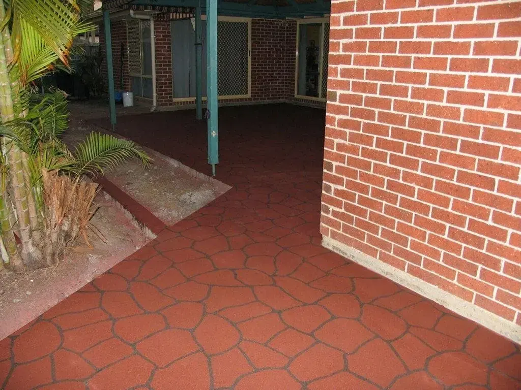 Courtyard resurfaced in a brick-red bush-rock pattern