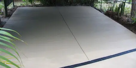 Broom-finish concrete carport slab with a strip drain