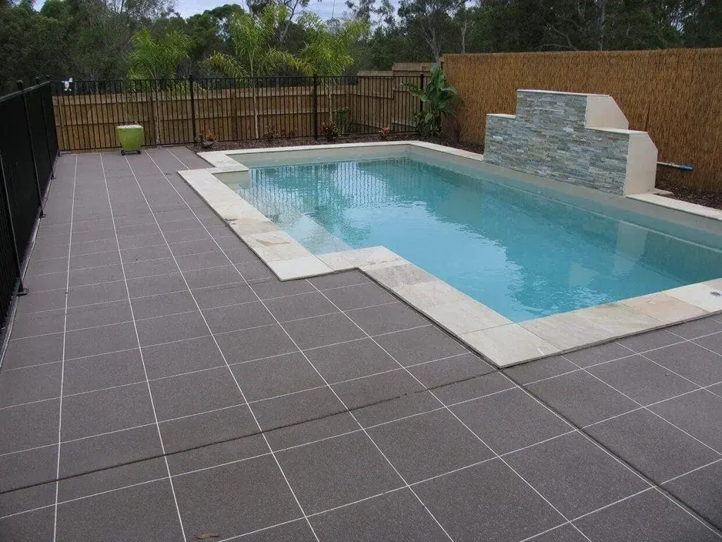 Pool surround resurfaced in a charcoal tile pattern with white grout lines
