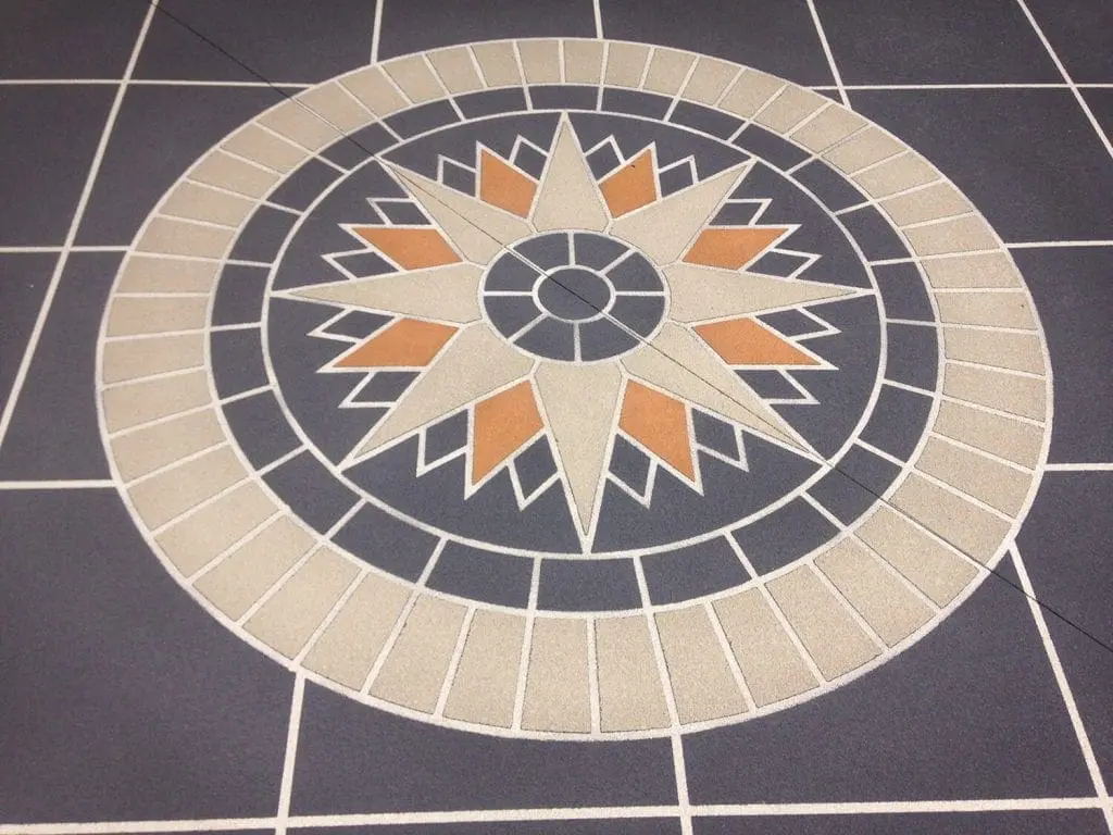 Close-up of a sandstone and terracotta compass rose stencil inlay