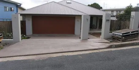 New concrete driveway and garage apron on a sloping street
