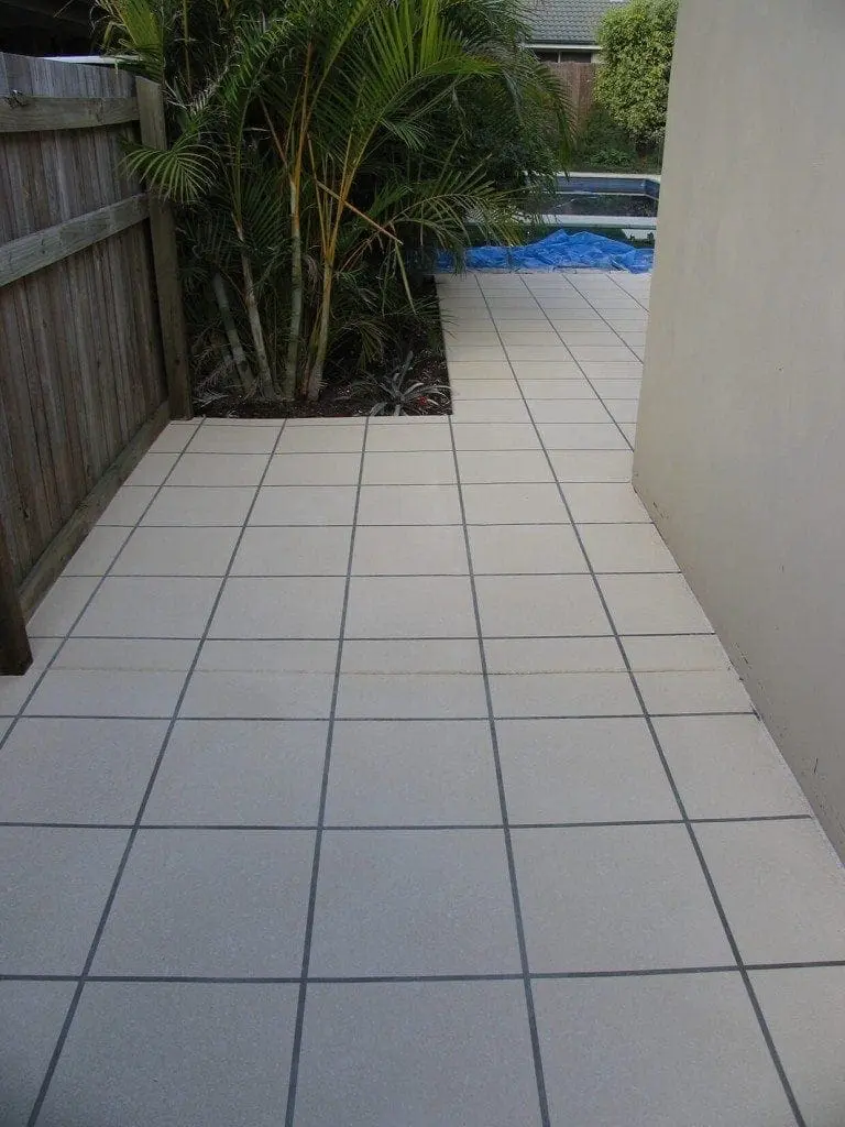 Side path resurfaced in cream square tiles leading to the pool