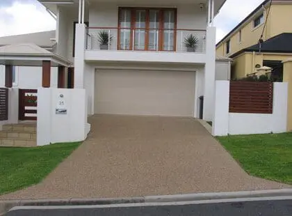 Exposed aggregate driveway leading to a townhouse garage