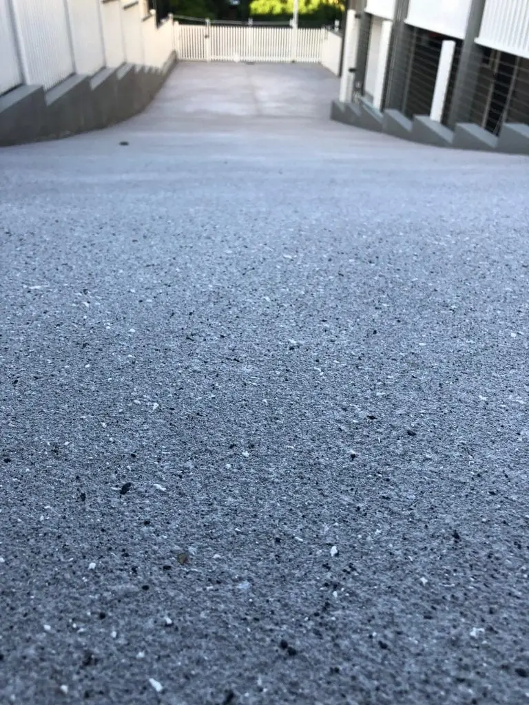 Sloping driveway resurfaced in a light grey fleck finish