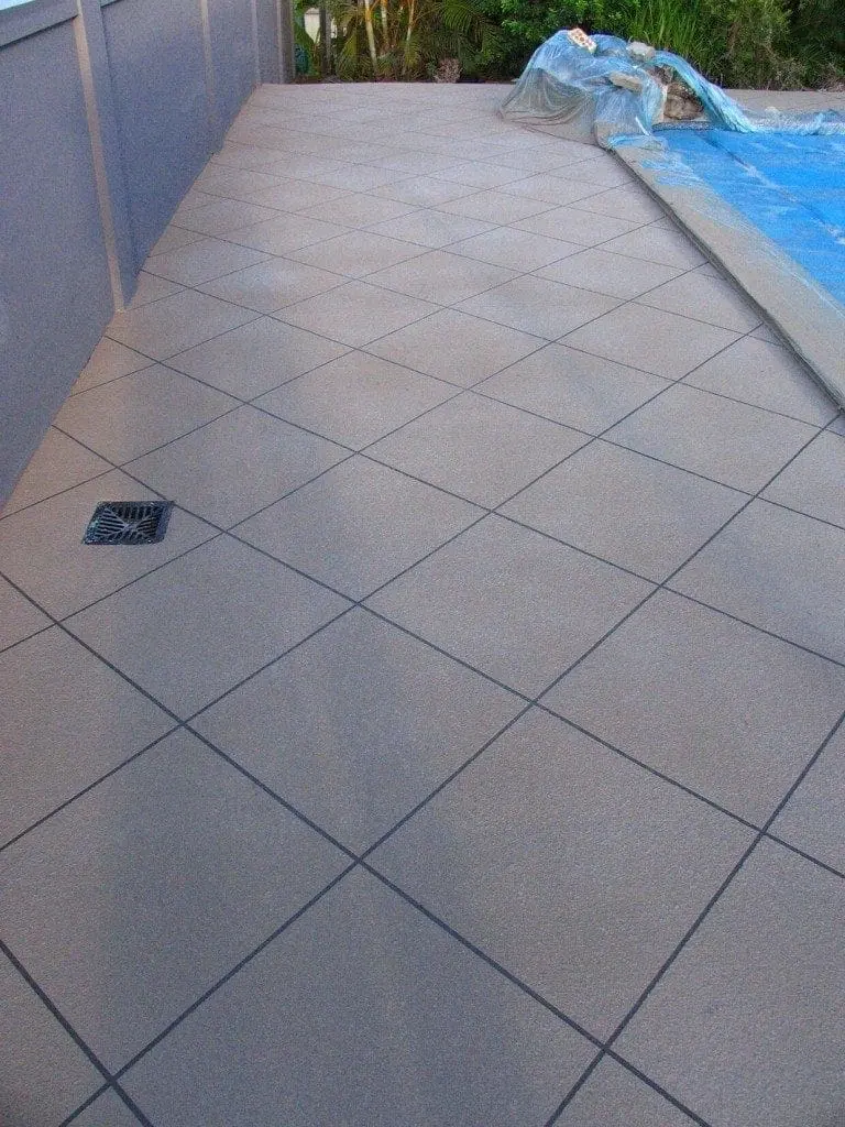 Path beside a pool resurfaced in grey diamond tiles