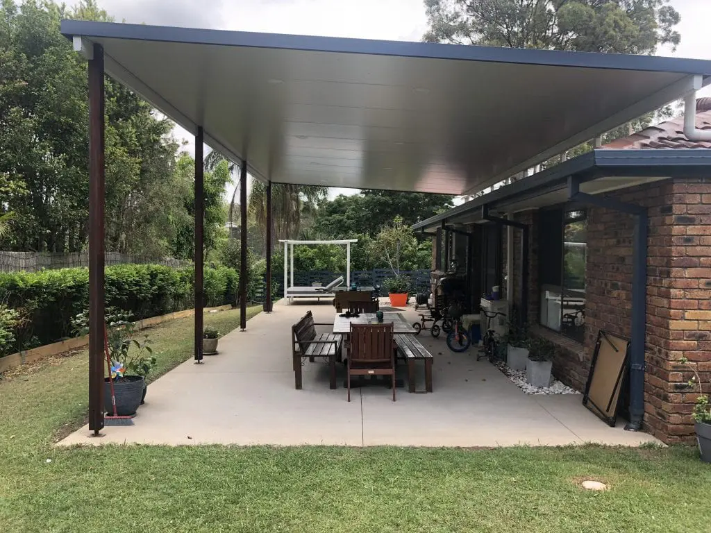 Plain concrete patio slab under a new flat patio roof