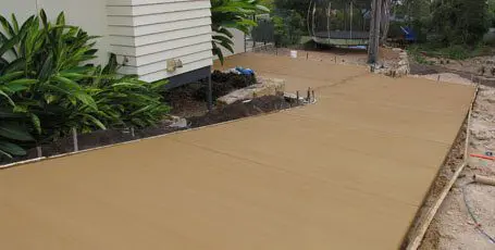 Freshly poured sandstone-coloured concrete pathway beside a house