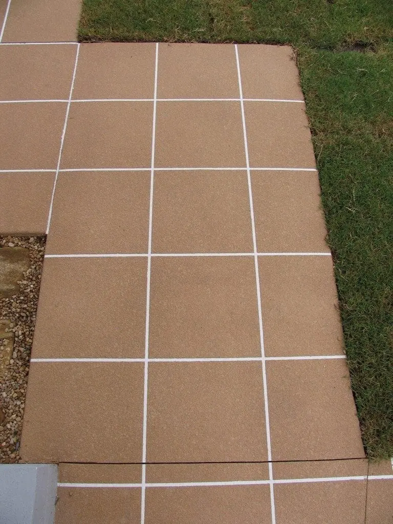 Footpath resurfaced in sandstone tiles with white grout lines