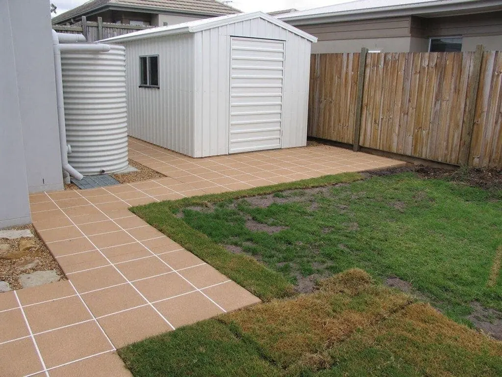 Backyard path and shed pad resurfaced in sandstone tiles with white grout