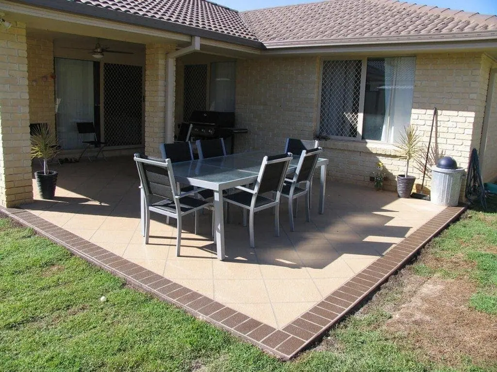 Alfresco patio resurfaced in sandstone tiles with a stencilled brick border