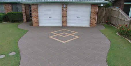 Tile-stencilled concrete driveway with a sandstone diamond feature