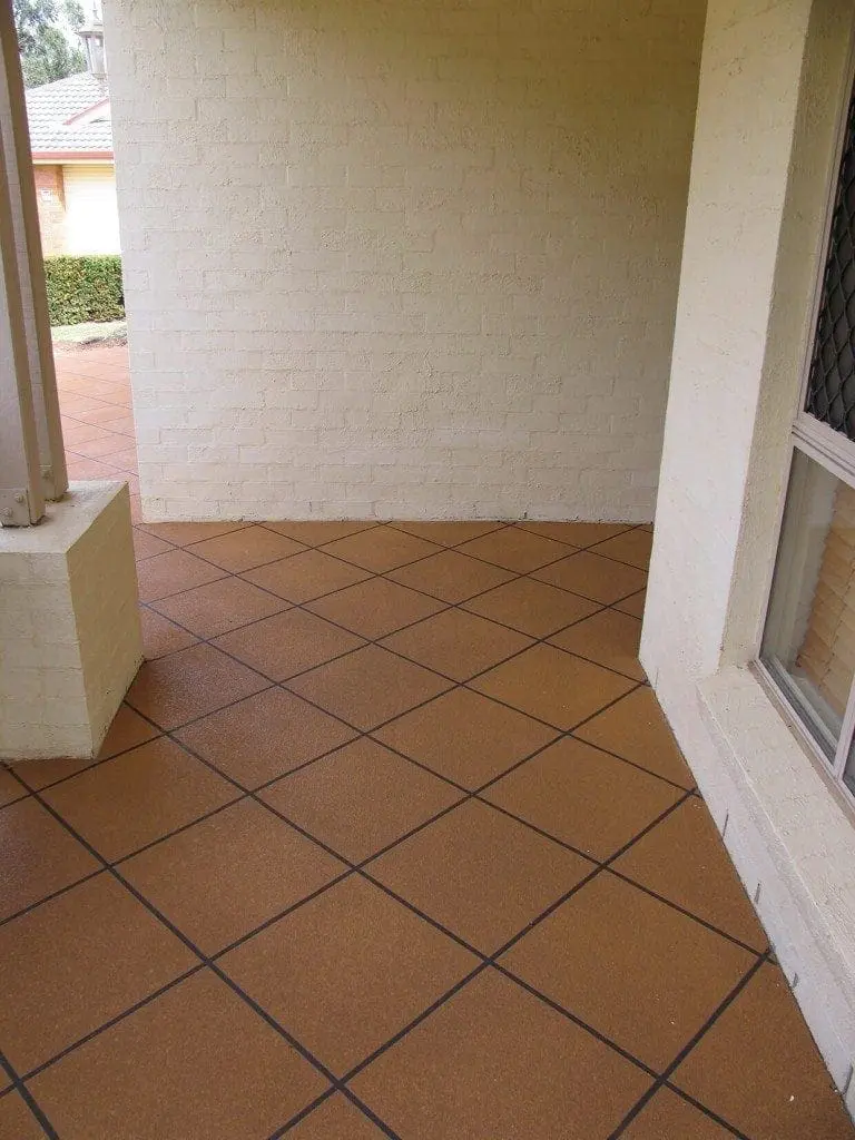 Covered porch resurfaced in terracotta diamond tiles with dark grout